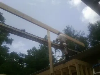 Carpenter setting a ridge beam over a new addition frame — Ice Dam Removal by Roofing Brothers in Mulberry