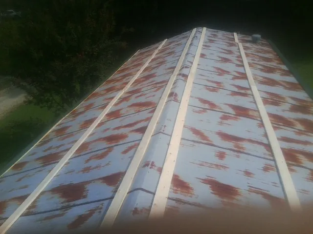 Rusted metal roof panels with new wood purlins before replacement — Storm Damage Roof Repair in Mulberry by Roofing Brothers