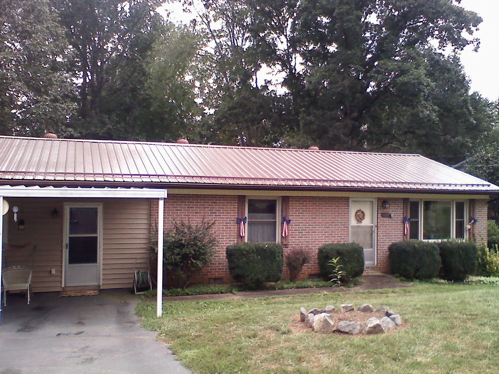 Bronze metal roof and carport on a brick ranch home in Mulberry